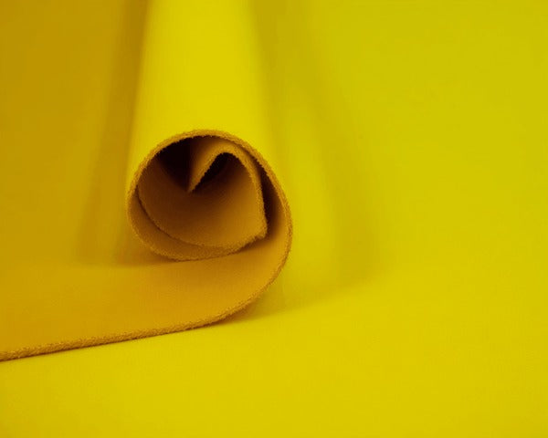 Vibrant yellow leather hide rolled for crafting, ideal for wholesale or artisan projects
